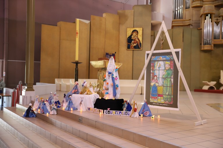 Réalisation des enfants exposée devant l’autel : statuettes de pèlerins et vitrail peint de l’apparition