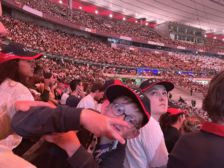 Des jeunes accompagnés de l’A.B.I.I.F., casquettes A.B.I.I.F. sur la tête, dans les tribunes du Stade de France